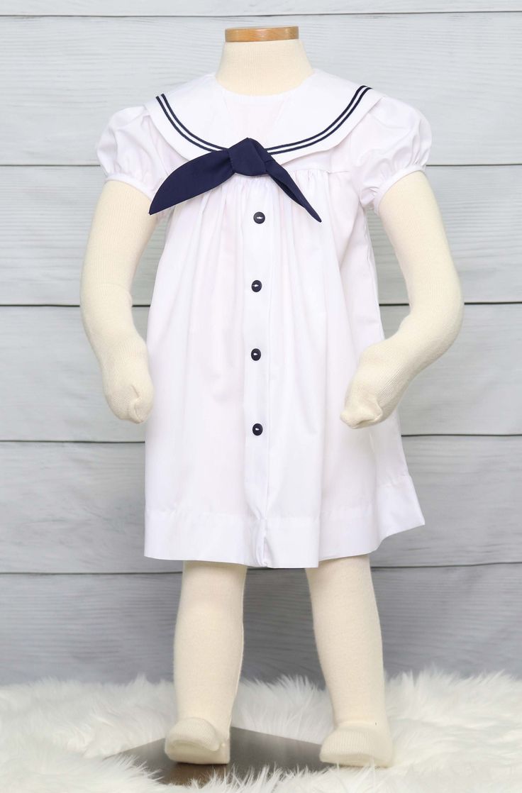 "She will look amazing in her nautical clothing for a nautical birthday in a sailor dress by Zuli Kids. Toddler sailor dress is shown in white with navy soutache trim on sailor collar. Also available in navy with white soutache trim. *Zuli Kids Premium Quality *Nautical Collar *Machine Wash Gentle *Button-Back Closures *Poly Cotton Fabirc *Puffed Sleeves *Short or Long Sleeves *Available in Sz 12 Mo - Sz 5 *Special Classic Garment to Commemorate the Special Day *Made in USA WHATS INCLUDED One sa Cute Navy School Dress, Summer Short Sleeve School Uniform Dress, Summer School Uniform Dress With Short Sleeves, Navy School Dress For Spring, Preppy Navy Cotton Dress, Preppy Fitted White Dress, Spring Sailor-style Short Sleeve Dresses, Navy Short Sleeve School Dress, Nautical Short Sleeve Summer Dresses