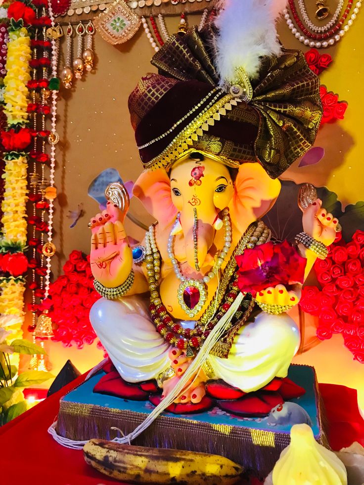 there is a statue of the god ganesh in front of flowers and garlands