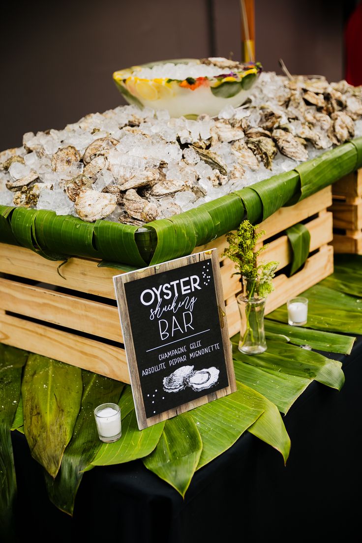 oysters on display in wooden crates at an outdoor event with menu and price tag