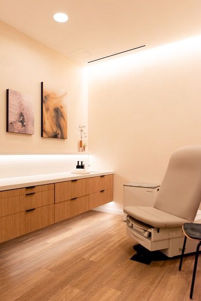 a chair sitting on top of a hard wood floor next to a bath room sink