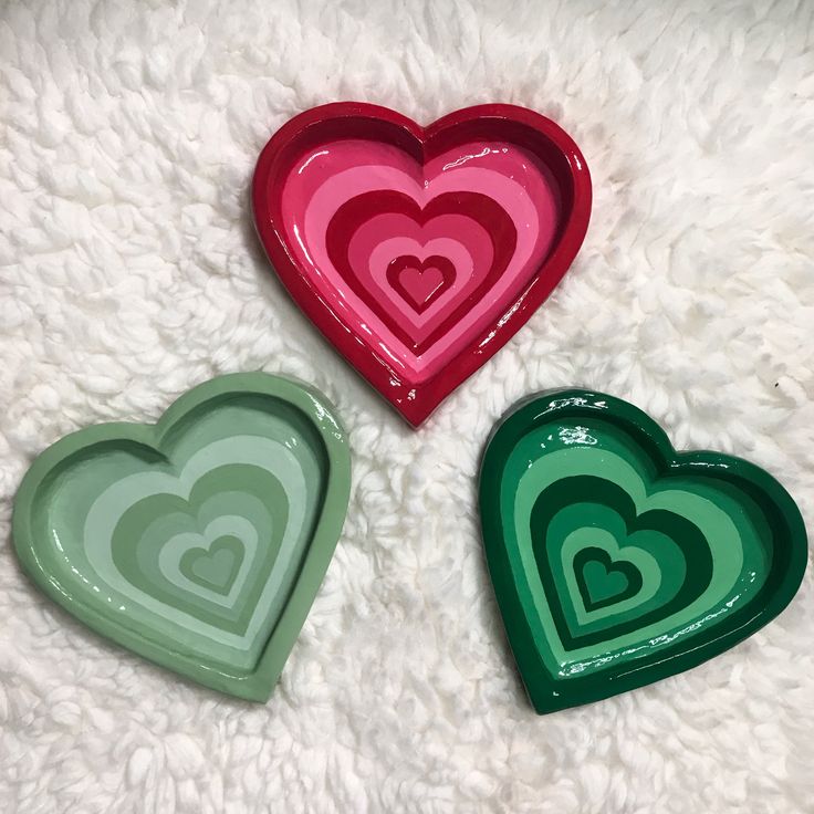 three heart shaped trays sitting on top of a white rug