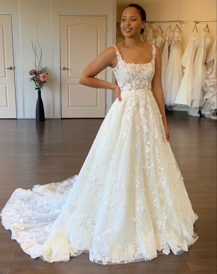 a woman standing in front of a wedding dress