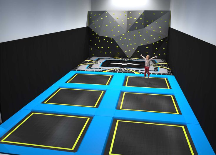 a person standing on top of a trampoline in a room with black walls