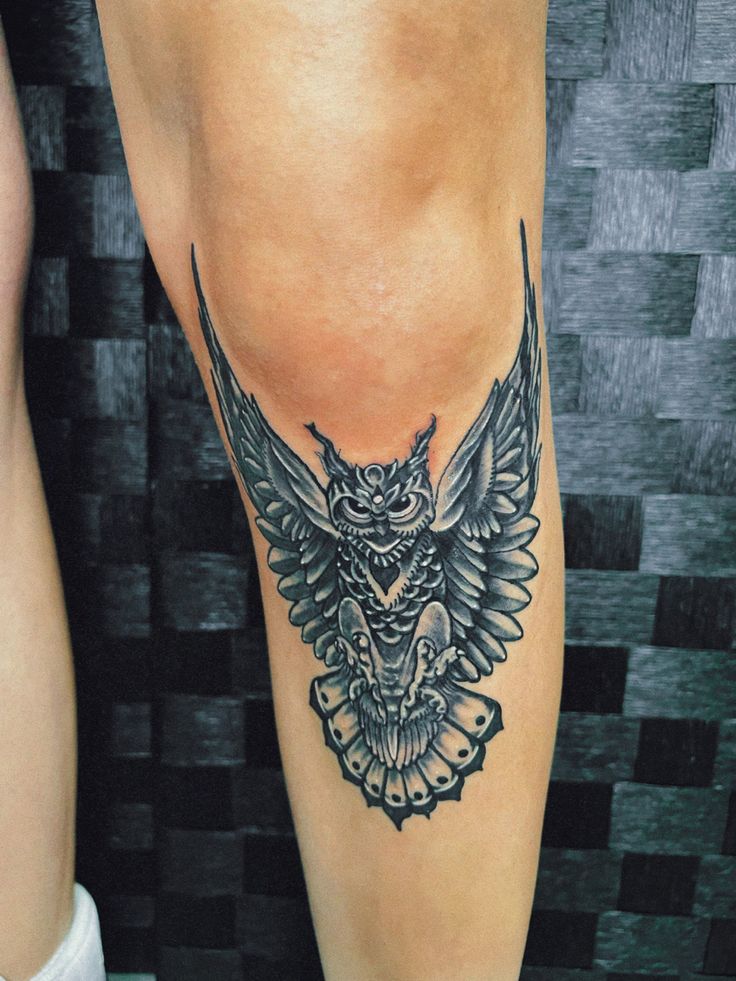 an owl tattoo on the leg of a woman