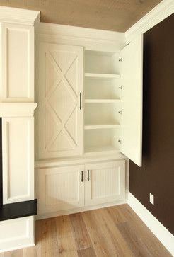 an empty room with white cabinets and wood floors