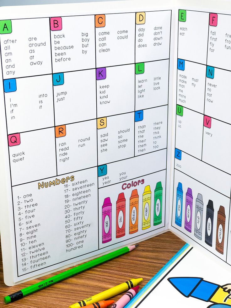 two calendars with colored crayons and pencils next to them on a table