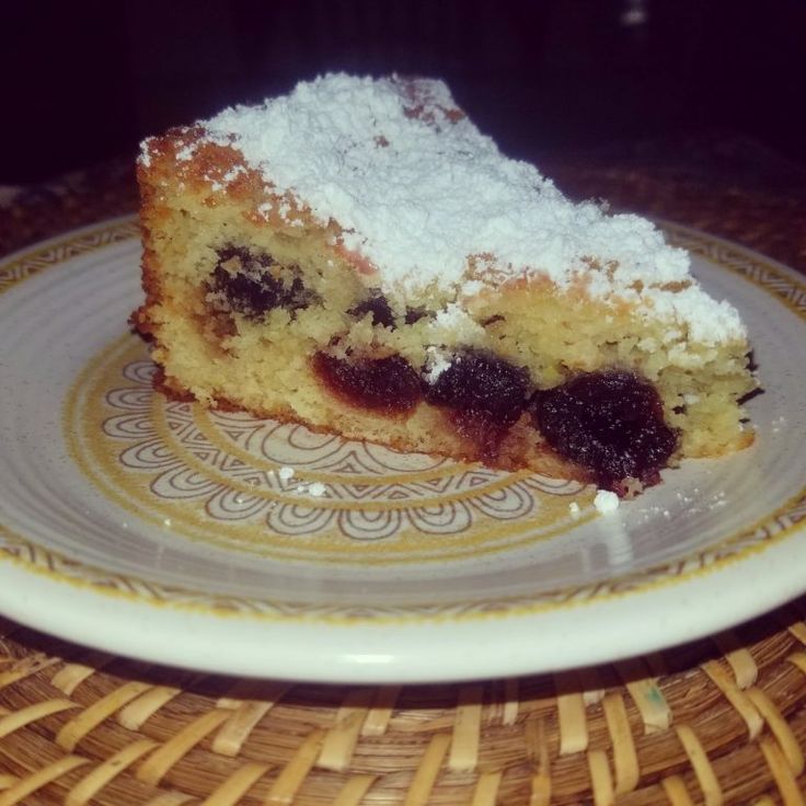 a piece of cake sitting on top of a white and yellow plate next to a wicker basket