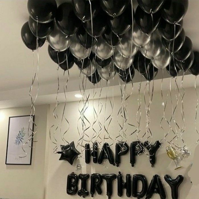 black and silver balloons with happy birthday written on the wall above them in an office setting