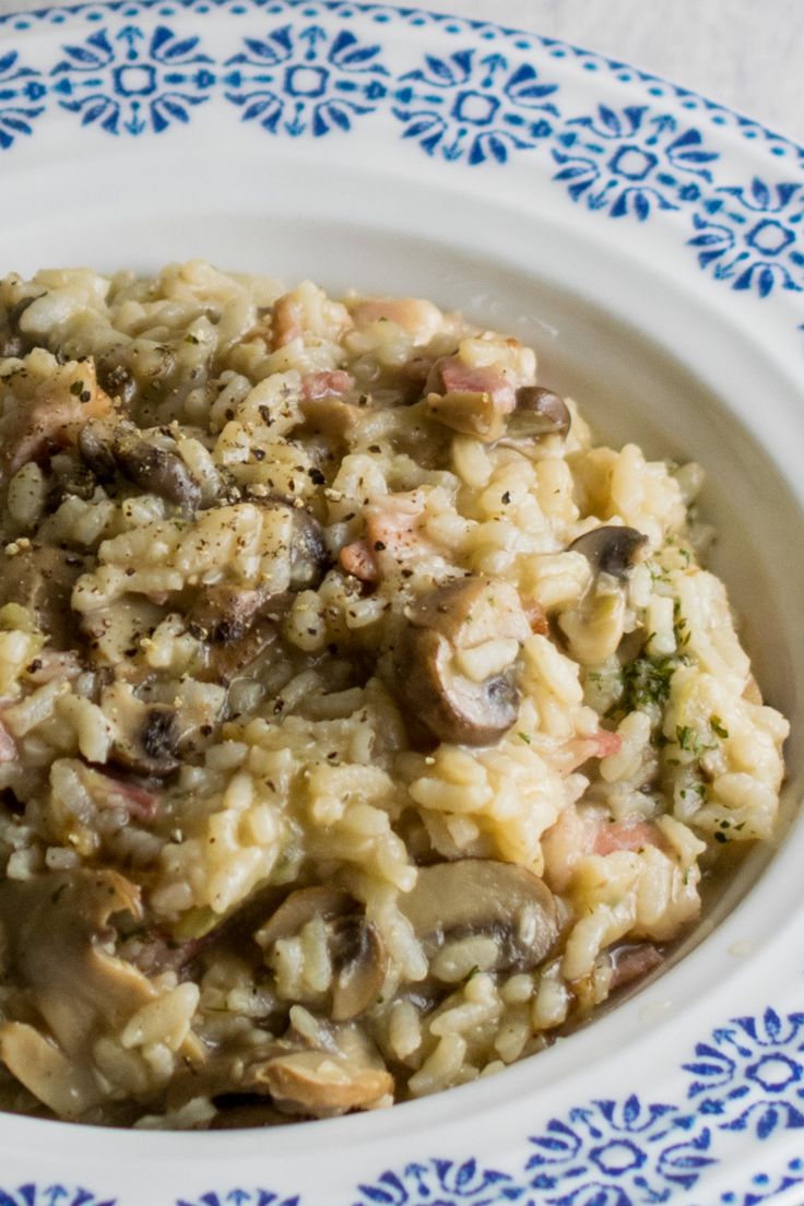 a bowl filled with rice and mushrooms on top of a blue and white plate topped with broccoli