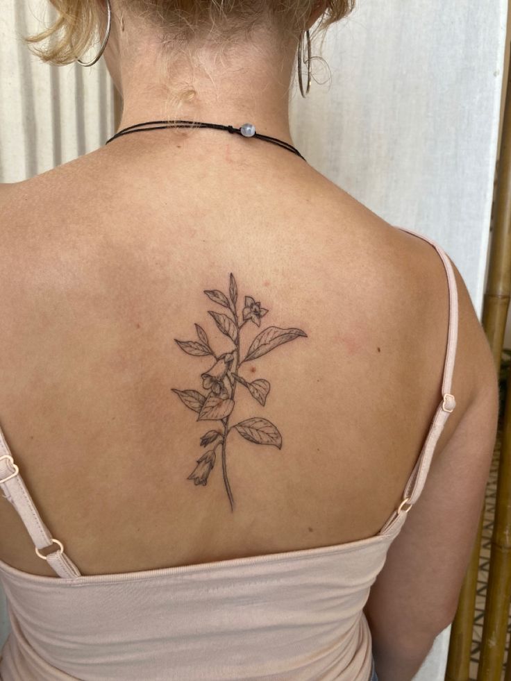 a woman with a flower tattoo on her back