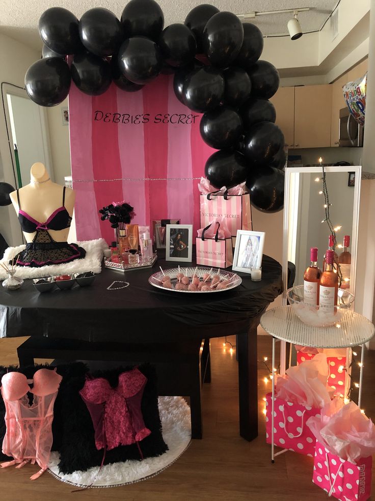 a table topped with lots of black balloons