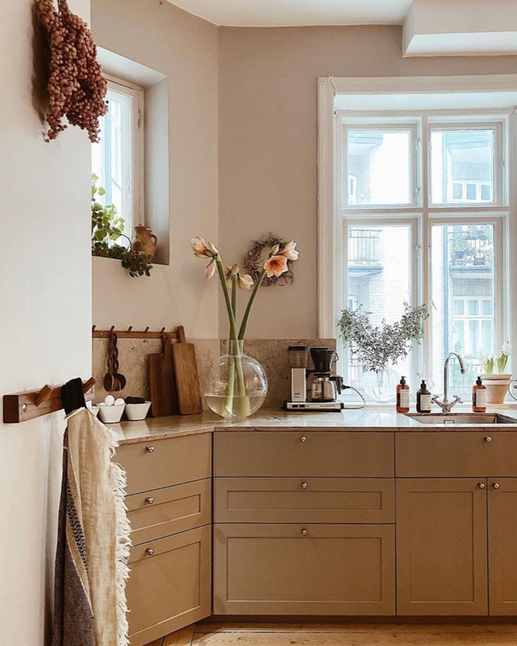 a kitchen filled with lots of counter top space next to a window and sink area