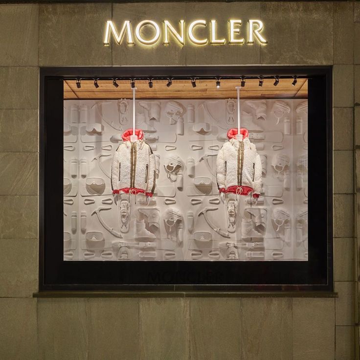 a store window with mannequins in front of it that says moncler