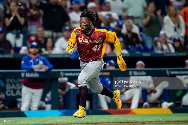 a baseball player running on the field during a game with fans in the stands behind him