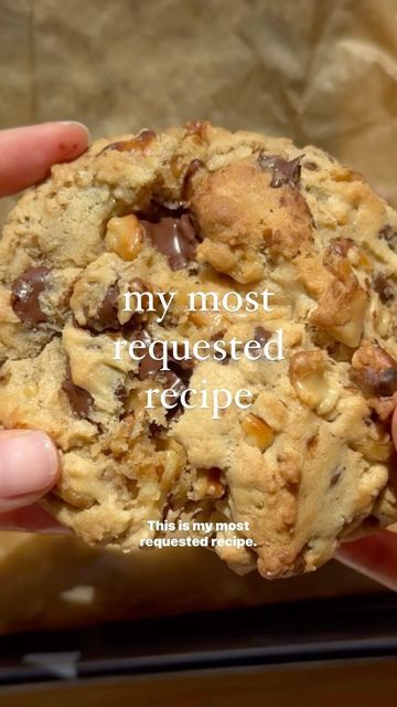 a person holding a chocolate chip cookie in their hand with the words, my most requested recipe