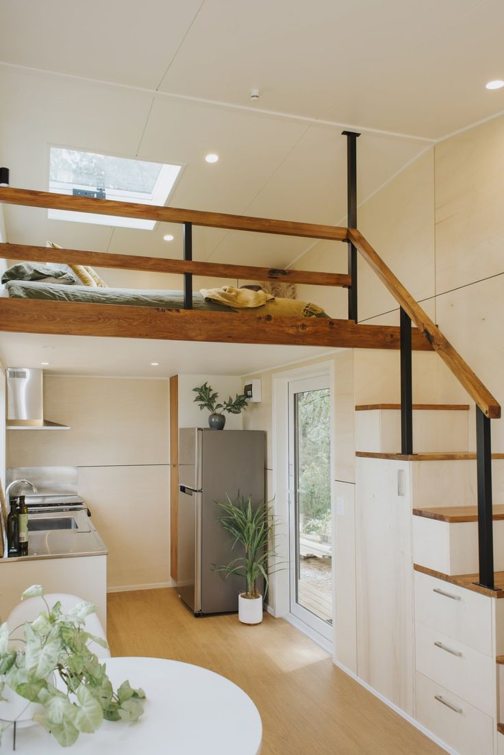 a kitchen and living room with stairs leading up to the loft