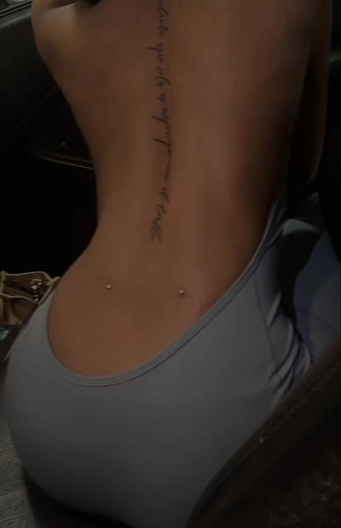 the back of a woman's body with writing on it