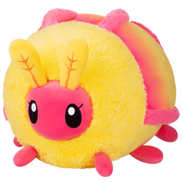 a yellow and pink stuffed animal with horns on it's head, sitting in front of a yellow background