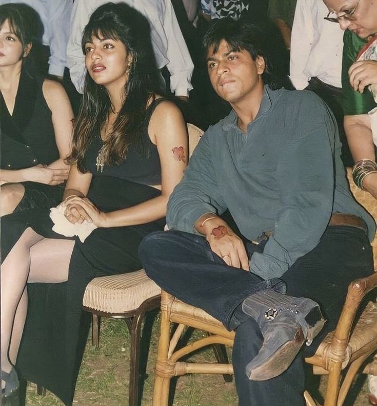 a group of people sitting next to each other on chairs in front of a crowd