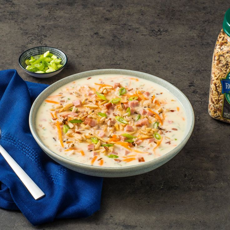 a bowl of soup with meat and vegetables next to a bag of salad seasoning