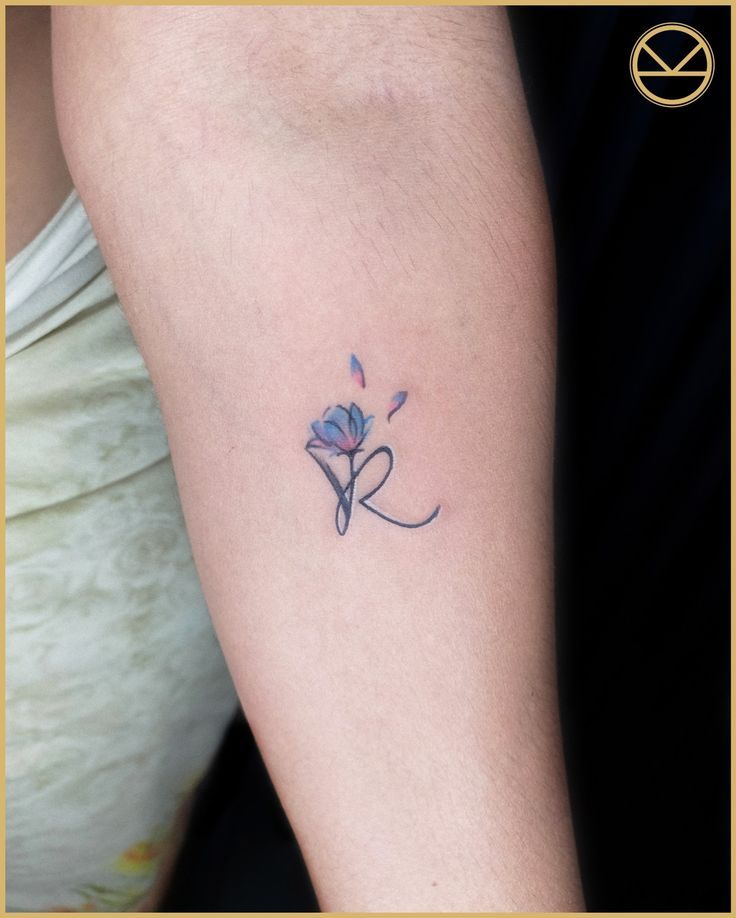 a woman's arm with a small flower tattoo on the left side of her leg