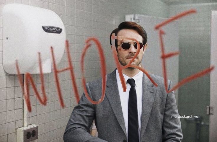 a man in a suit and tie standing in front of a urinal with the word shower written on it