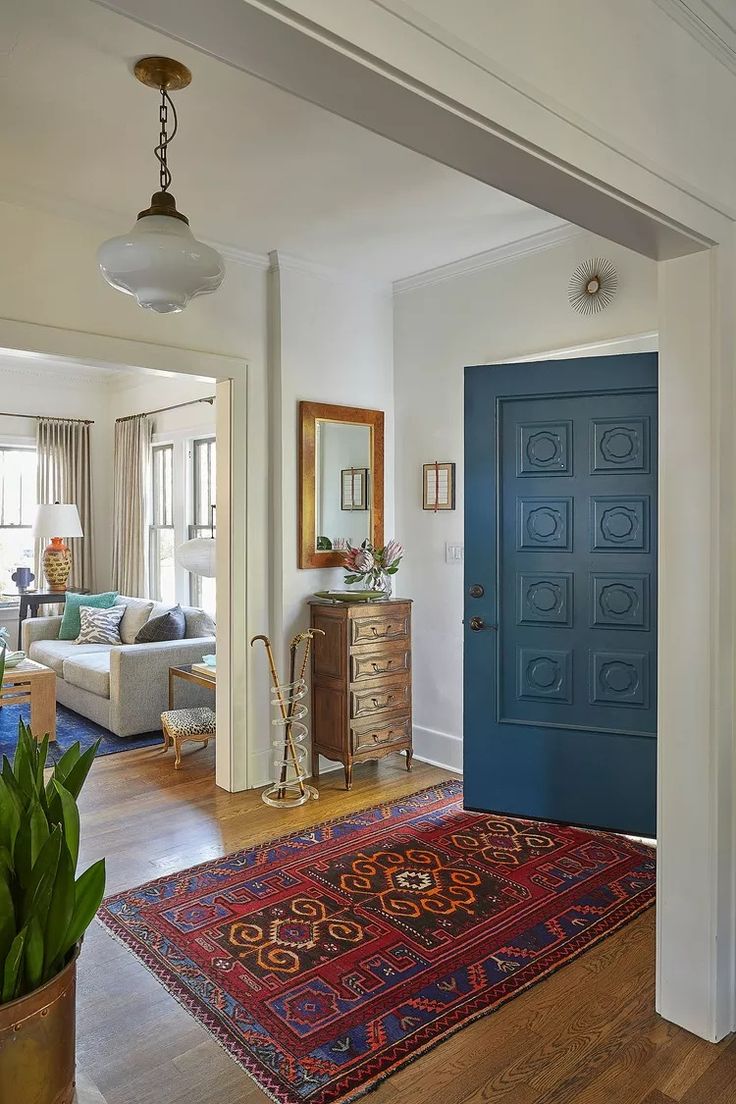 a living room with a blue door and rug on the floor