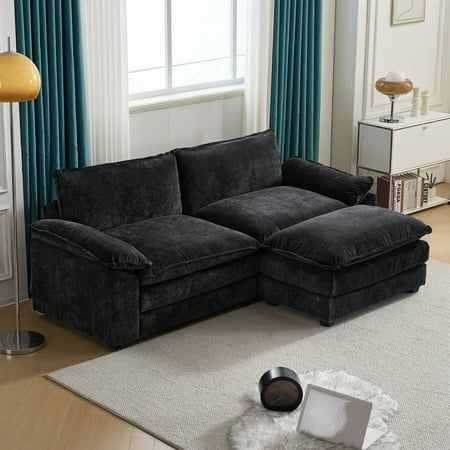 a living room with a black couch and white rug