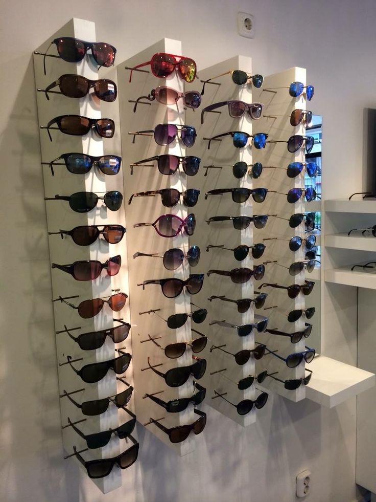 many pairs of sunglasses are hanging on the wall