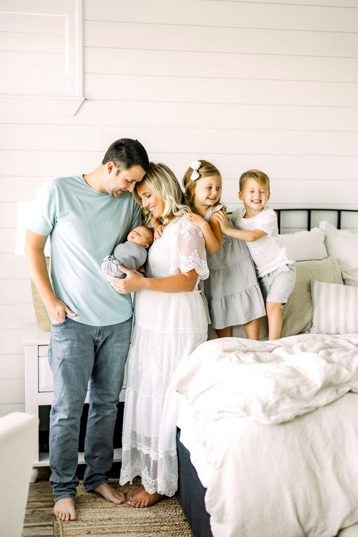 a family standing in front of a bed