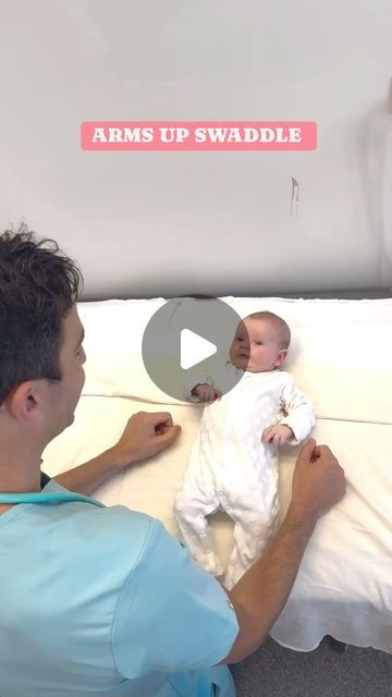 a man holding a baby on top of a bed