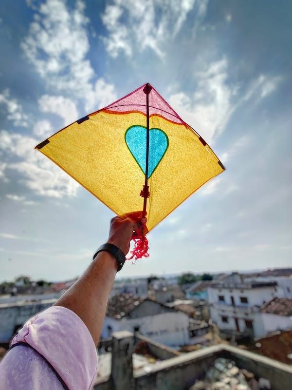 a person holding a colorful kite in their hand