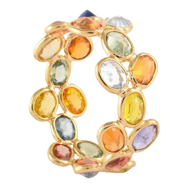 a gold bracelet with multicolored stones on the front and back of it's clasp