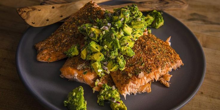 a blue plate topped with fish and broccoli