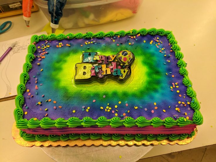 a birthday cake with the word baby spelled out in rainbow icing and sprinkles