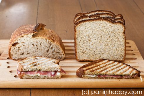 a wooden cutting board topped with sliced sandwiches