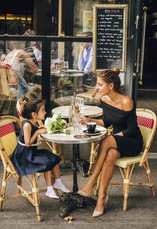 a woman sitting at a table with two small children