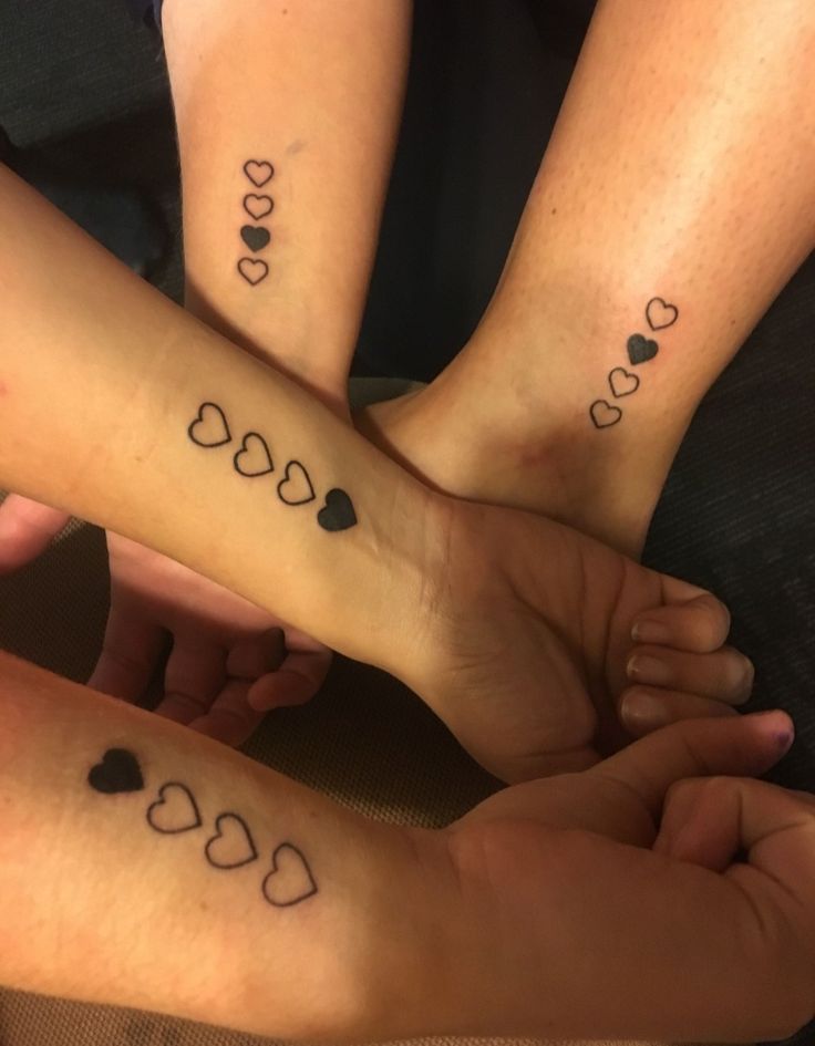 three people with matching tattoos on their feet are holding each other's hands together