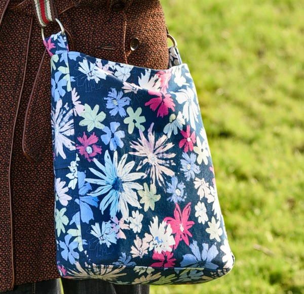 a woman carrying a blue and pink floral bag