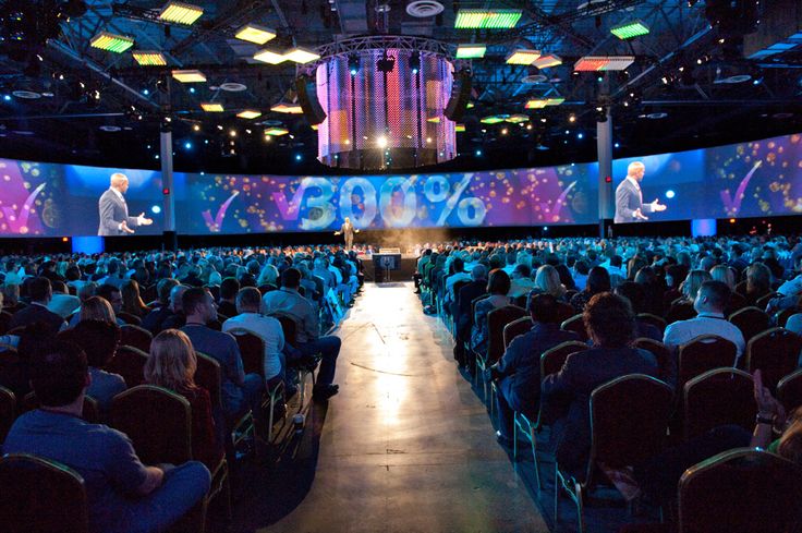 a large auditorium filled with people sitting in front of a projector screen that reads 350