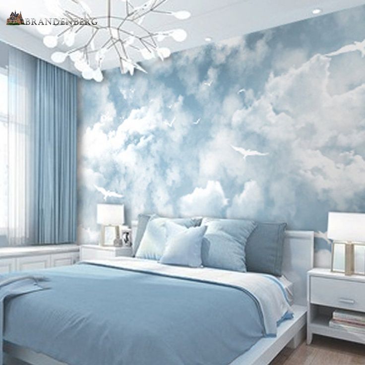 the bedroom is decorated in blue and white with clouds painted on the wall behind it