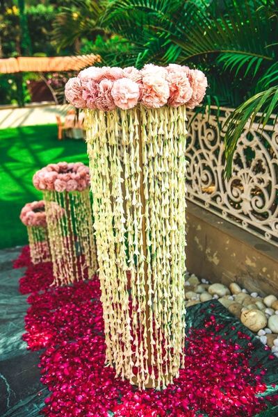 pink and white flowers are hanging from the side of a tall planter in front of a