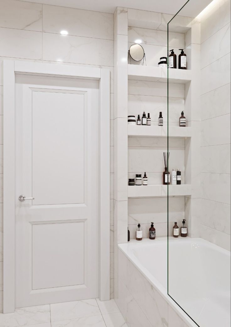 a bath room with a tub a shelf and a door