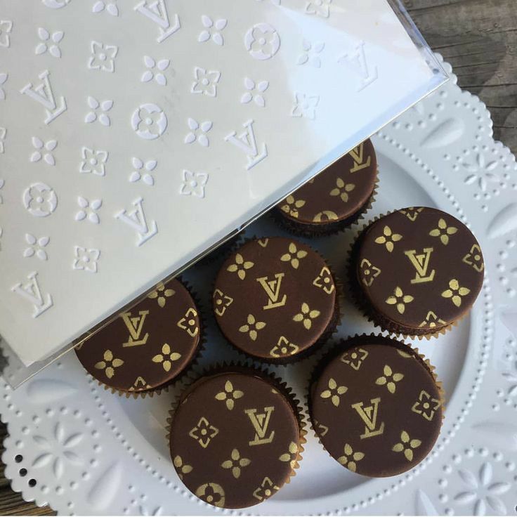 chocolate cupcakes with louis vuitton designs on them sitting on a white plate