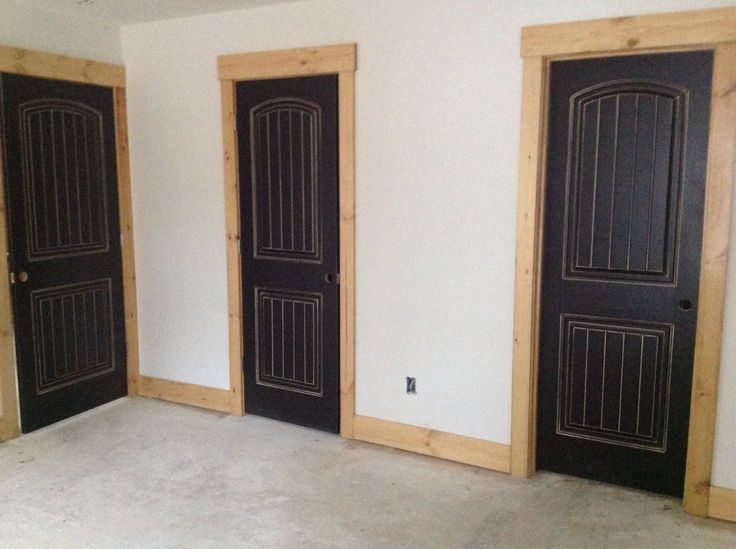 an empty room with three black doors in it