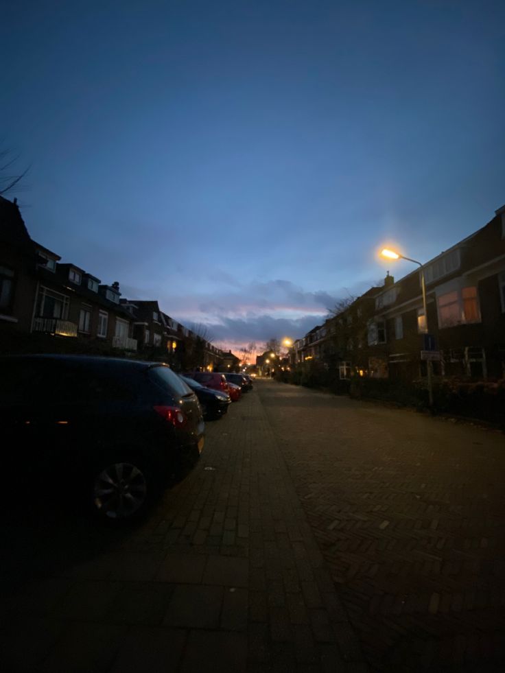 cars parked on the side of a street at night