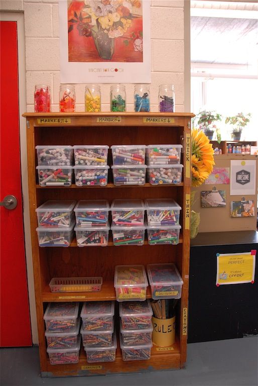 a book shelf filled with lots of books next to a red door