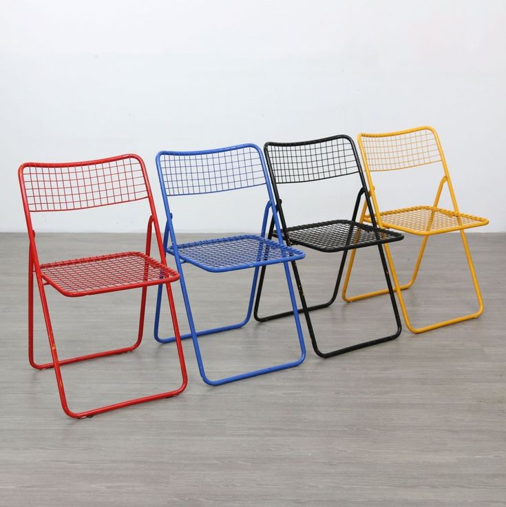 four different colored chairs sitting on top of a wooden floor