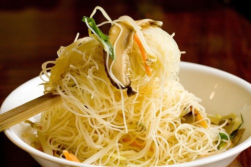 a white bowl filled with noodles and vegetables