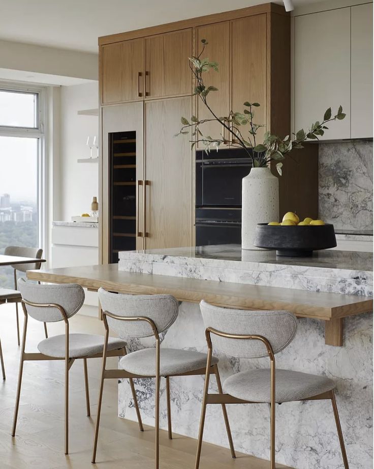 a kitchen with marble counter tops and chairs